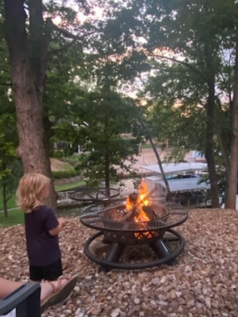 child enjoying a bon fire by the water